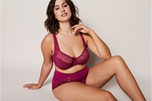 Femme en soutien-gorge appuyée contre un cadre de porte