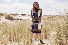 Femme avec pull bleu sur la plage