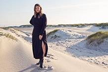 Frau mit blauem Pullover am Strand