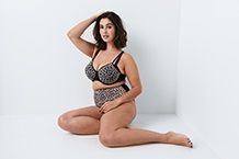 Femme en soutien-gorge appuyée contre un cadre de porte