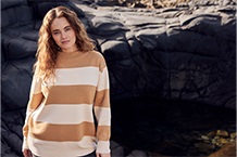 Frau mit blauem Pullover am Strand
